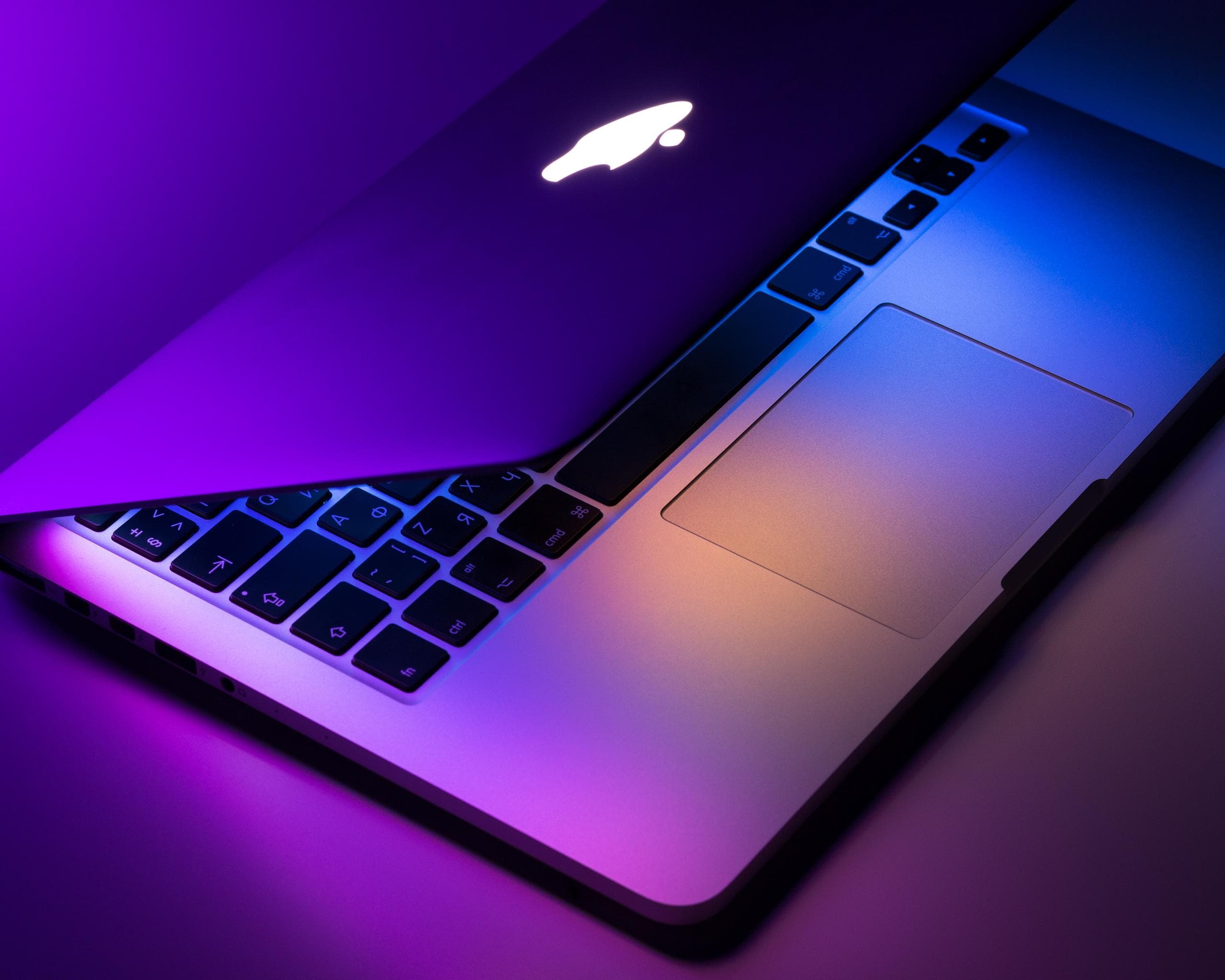 Apple laptop with purple and orange lights