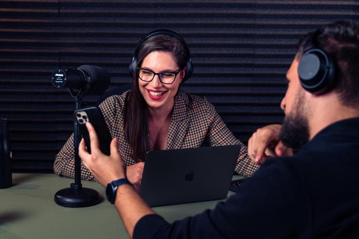 Man and woman recording podcast in studio with microphones