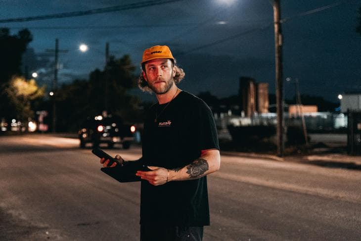 Man with yellow baseball cap standing in the street