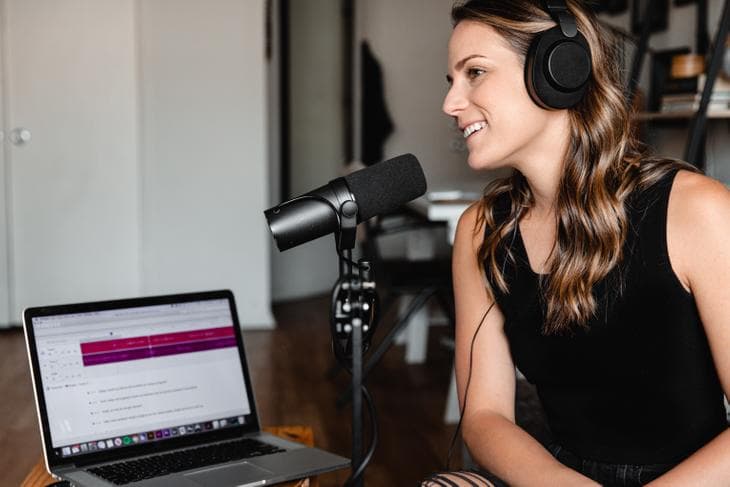 Woman podcasting with laptop and microphone